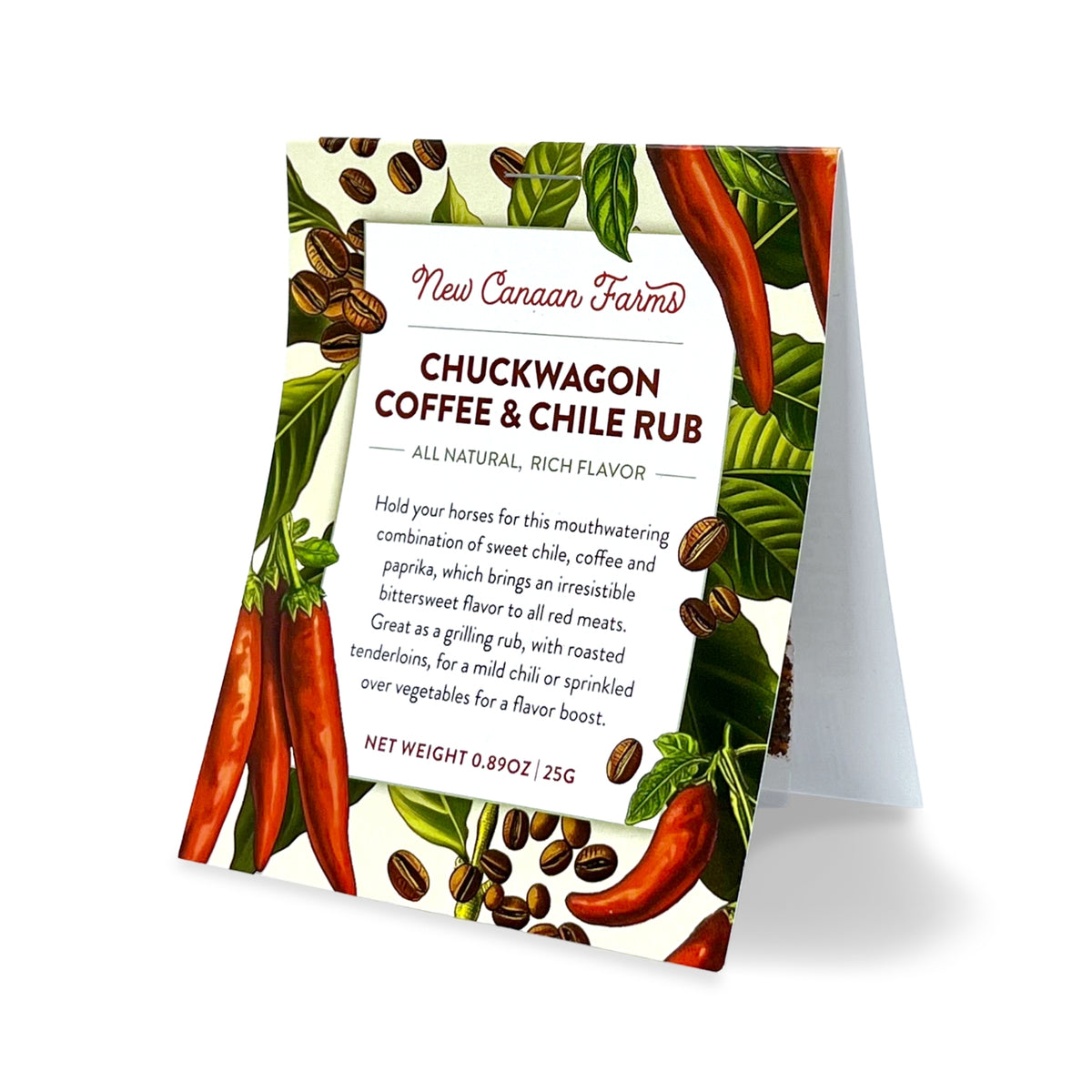 A packet of New Canaan Farms Chuckwagon Coffee & Chile Rub standing upright, with coffee beans and red chiles on the label