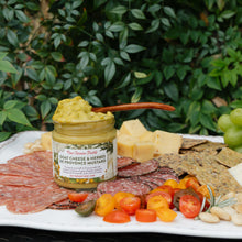 New Canaan Farms Goat cheese and herbs de Provence mustard on a charcuterie board with meats, cheeses, and vegetables.