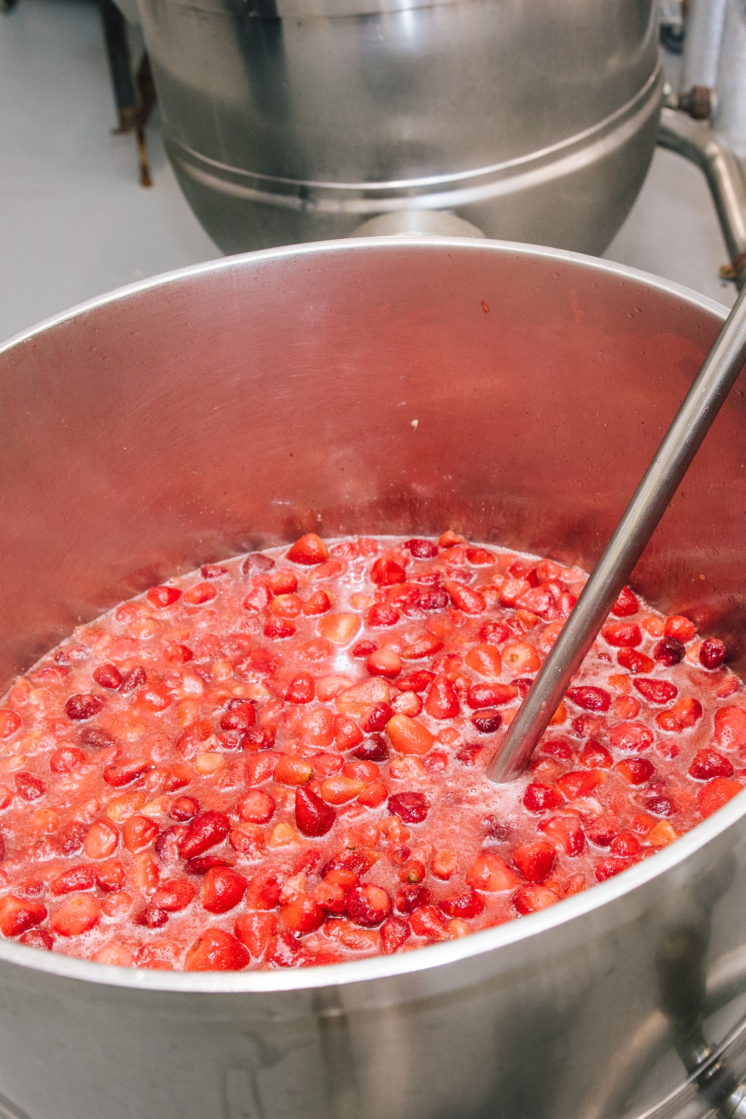 Large metal pot filled with boiling berries 
