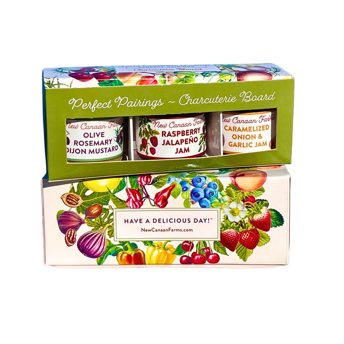 New Canaan Farms Perfect Pairings Charcuterie Board box with three jars in the window, set on a fruit-illustrated gift box