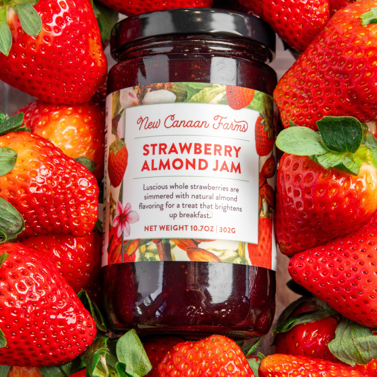 Jar of New Canaan Farms Strawberry Almond Jam surrounded by strawberries