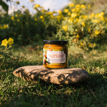 Jar of sun-dried tomato and basil mustard on a stone with a natural background