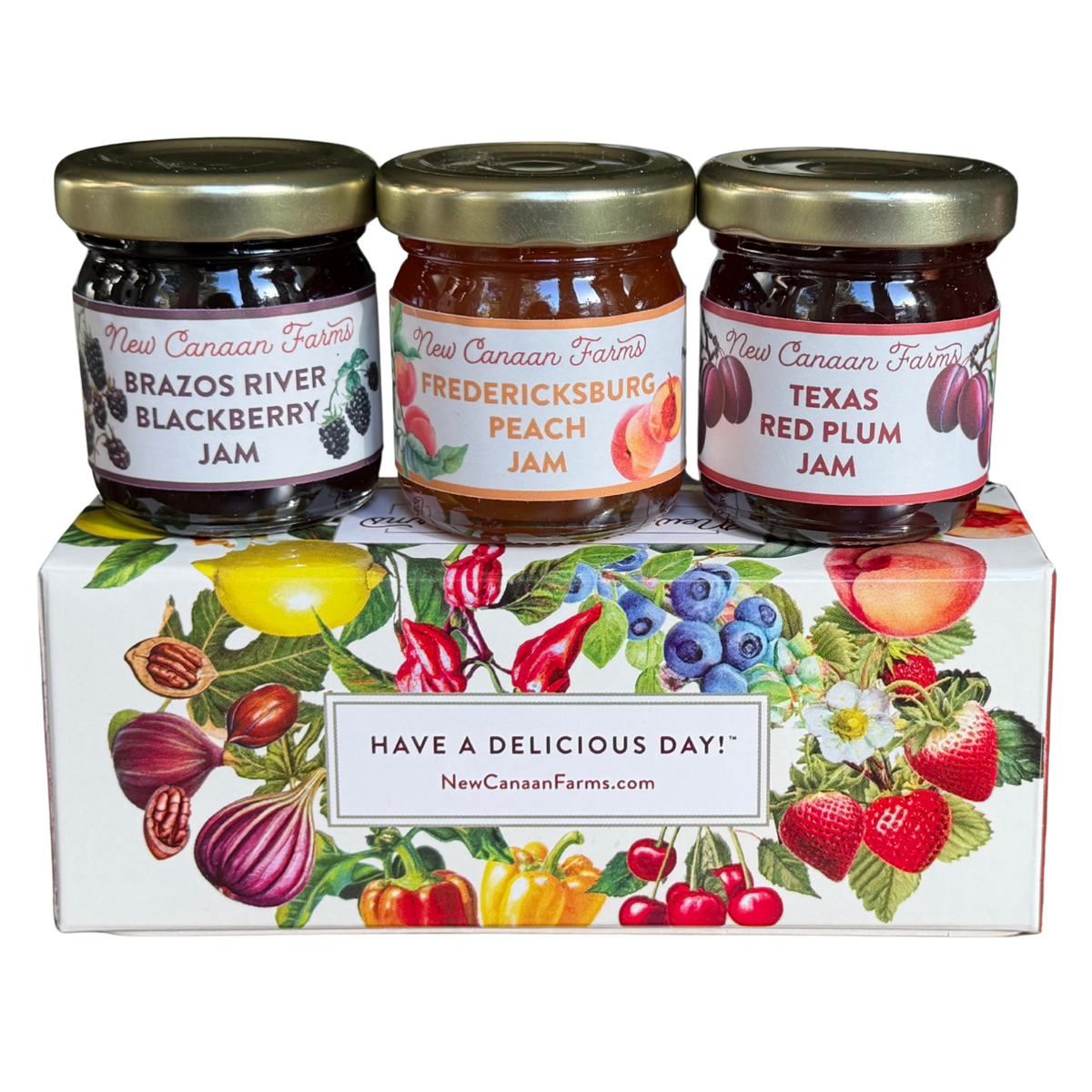 Mini jars of Brazos River Blackberry, Fredericksburg Peach and Texas Red Plum Jam on a fruit-illustrated Perfect Pairings box