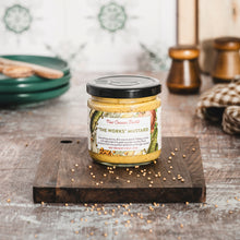 Jar of 'The Works' mustard on a wooden board with a rustic background