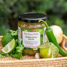 Jar of New Canaan Farms Verde Chili Salsa with ingredients on a woven mat