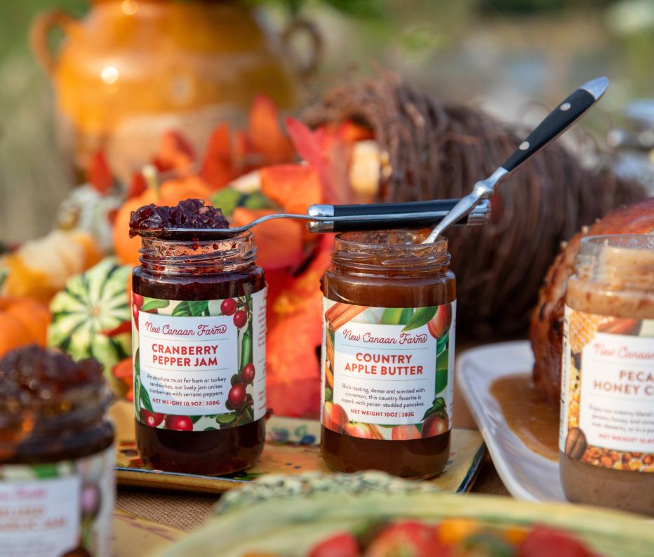 Cranberry Pepper Jam and Country Apple Butter on a fall table with pumpkins and gourds