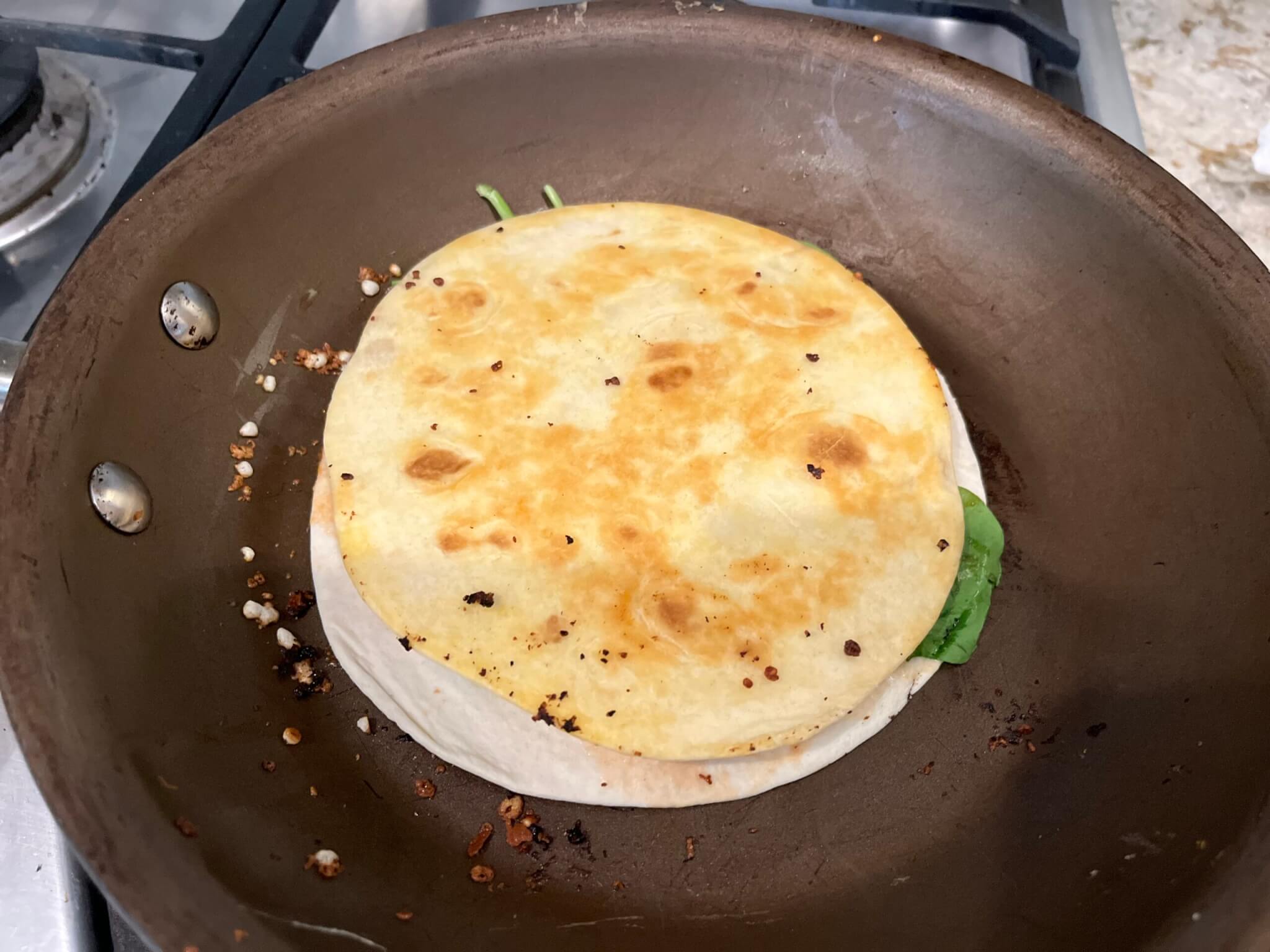 Goat's Cheese, Black Bean and Corn quesadilla cooking in a frying pan