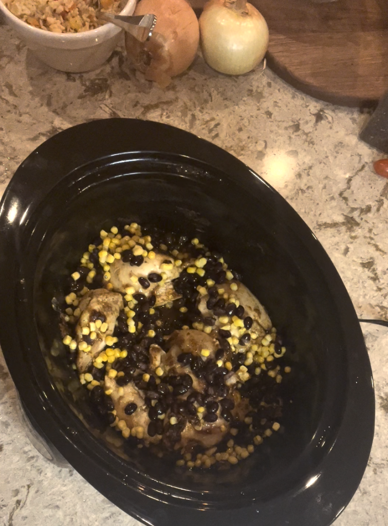 Adding frozen corn and black beans to chicken cooking in a crockpot