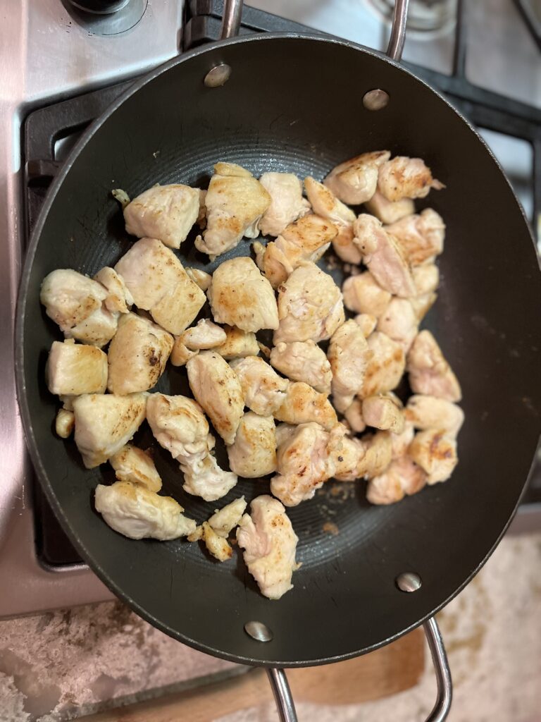 Cooking chicken pieces in a frying pan
