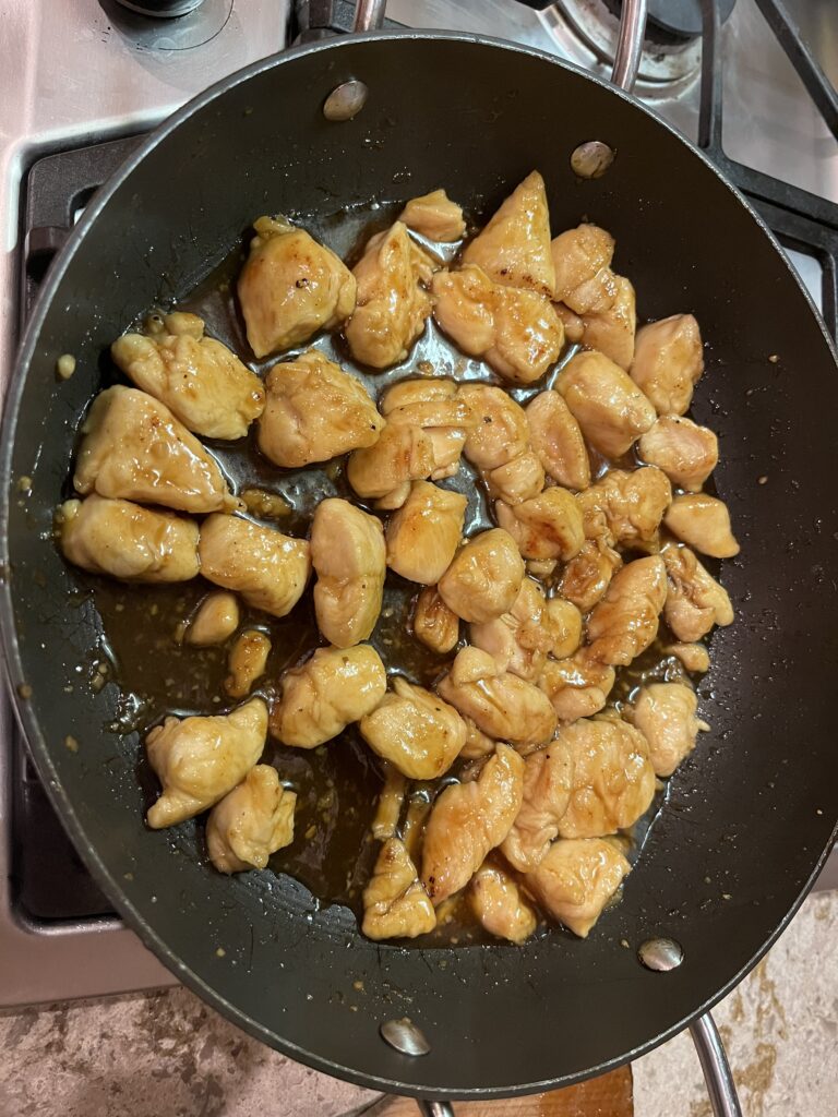 Chicken pieces glazed with New Canaan Farms apricot jam cooking in a skillet