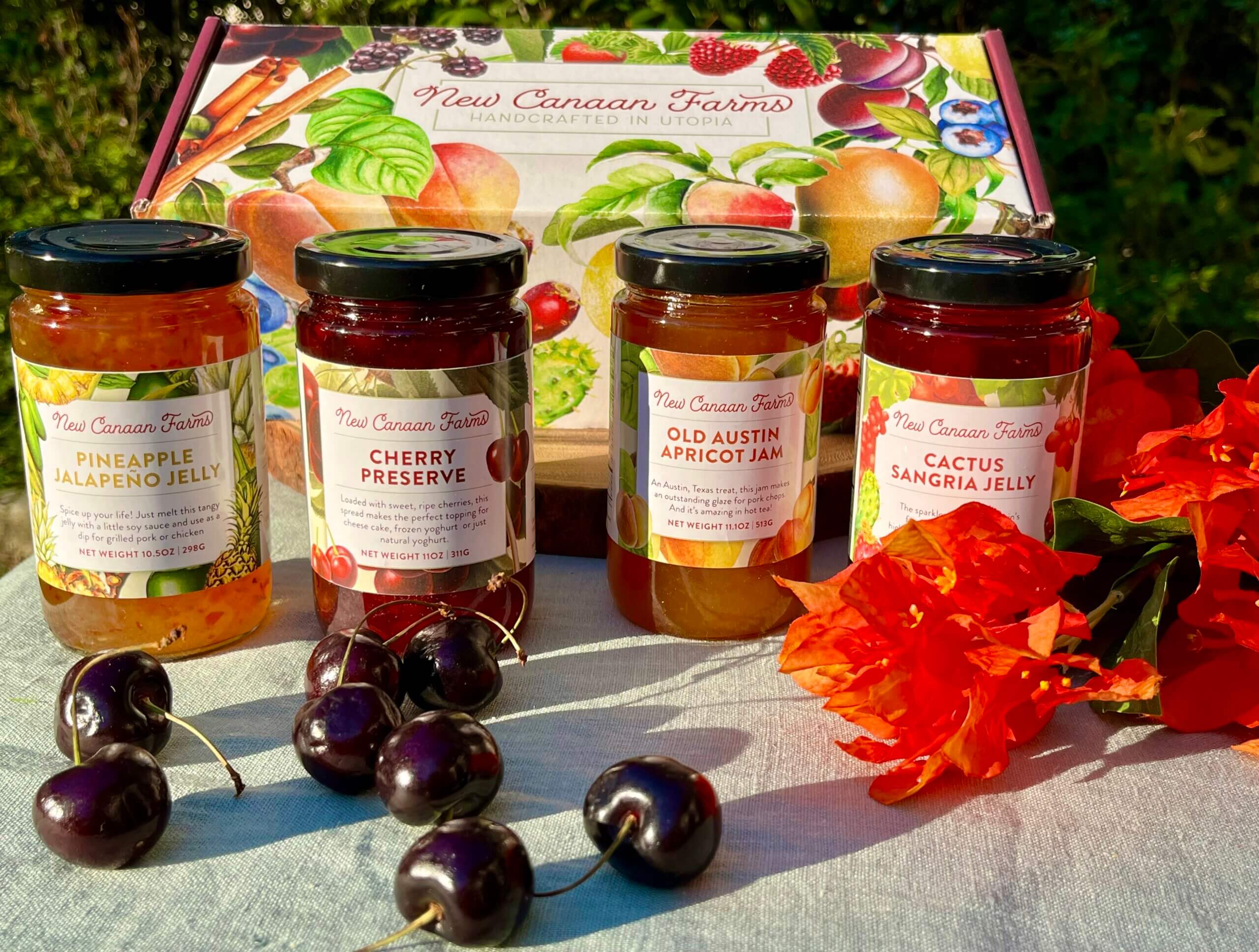 A collection of New Canaan Farms jams of fruit that ripens in Spring; Old Austin Apricot Jam, Cactus Sangria Jelly, Cherry Preserves and Pineapple Jalapeño Jelly