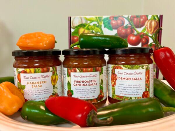 Three spicy New Canaan Farms salsas - Habanero, Demon and Fire-Roasted Cantina - surrounded with jalapeños and chilis