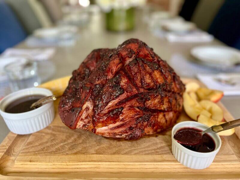 A large cooked ham butt, glazed with New Canaan Farms Raspberry Chipotle Sauce and ready to serve