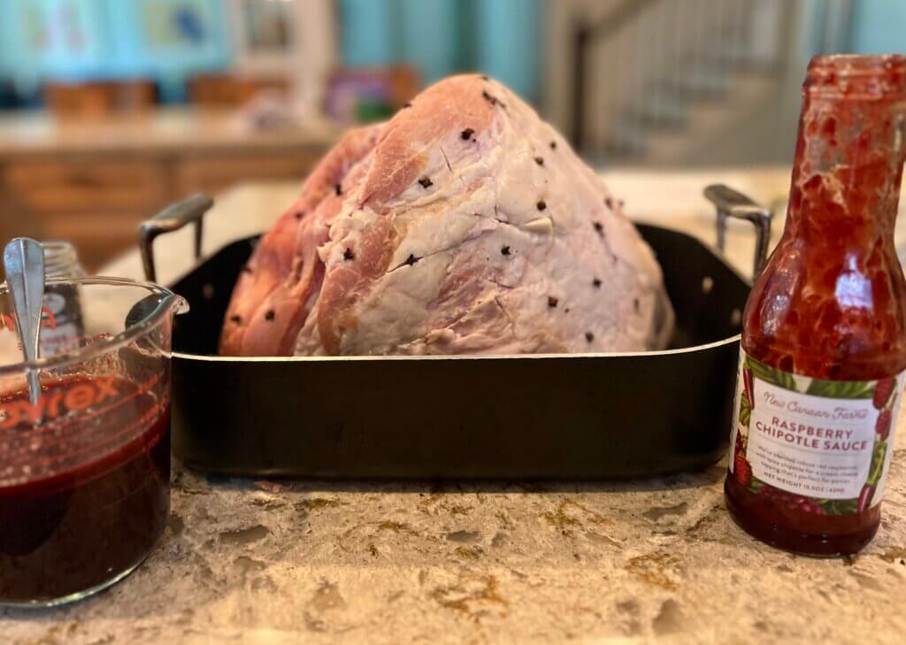 A large ham butt, studded with cloves in a baking dish, and ready to go in the oven