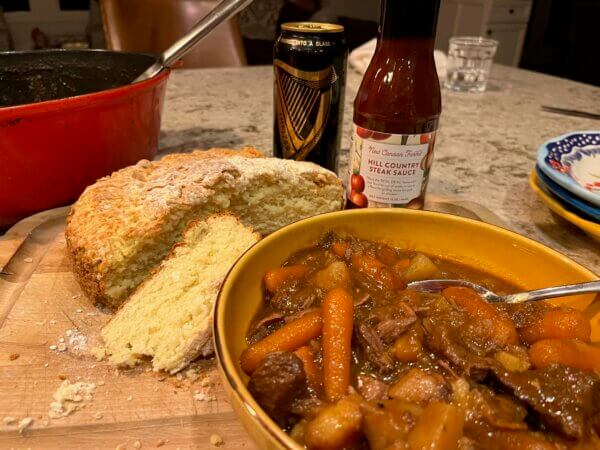 A bowl of Irish stew with Irish Cheese Soda Bread and New Canaan Farms Hill Country Steak Sauce