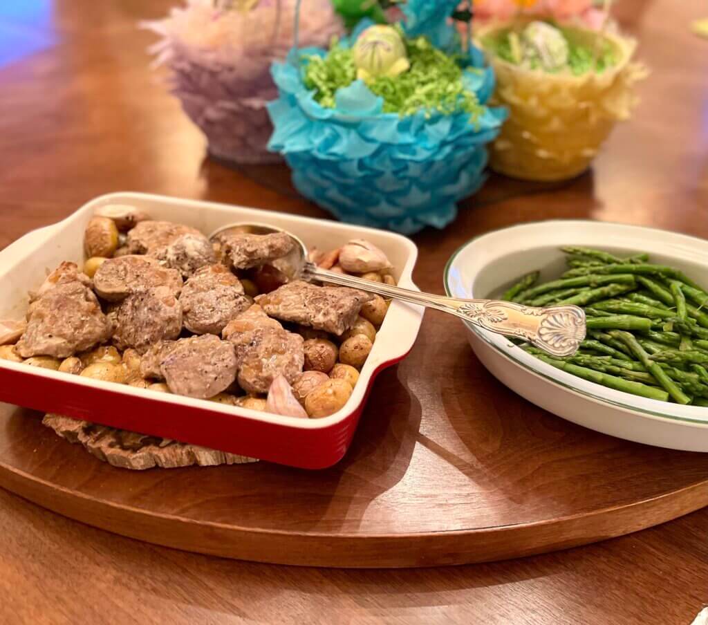 Pork tenderloin medallions in a rich sauce, on a bed of roasted mini potatoes and garlic, and served with steamed asparagus