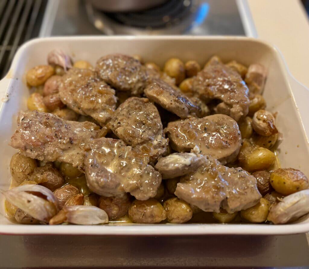 Pork tenderloin medallions served on a bed of mini roasted potatoes and garlic