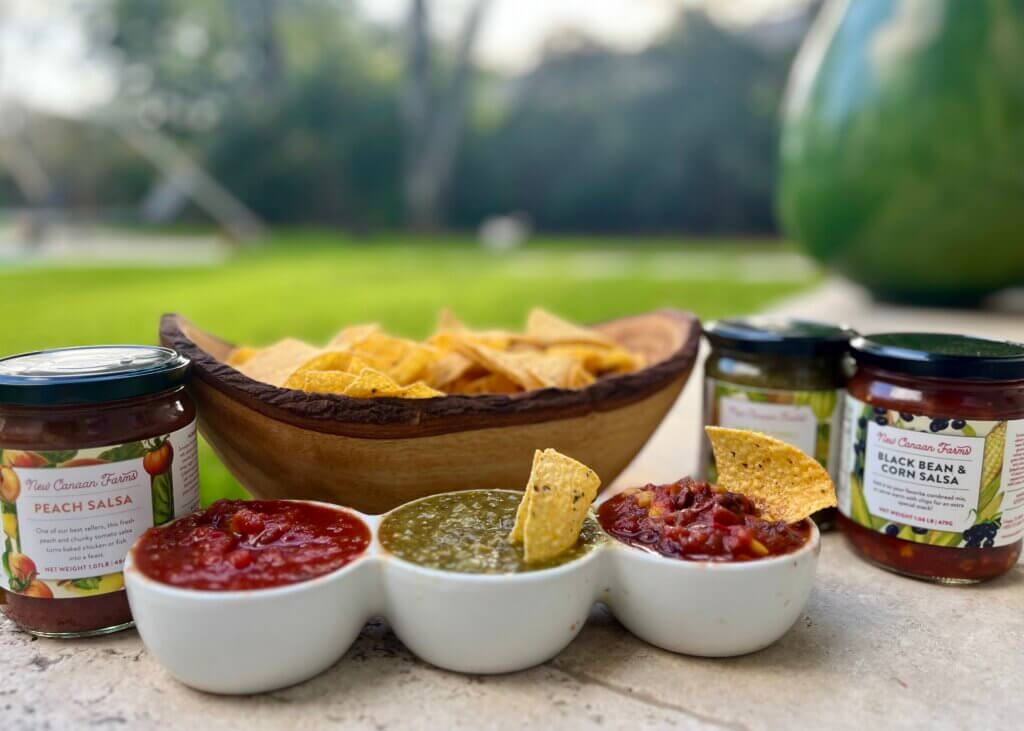 Three New Canaan Farms salsas served in white bowls with tortilla chips