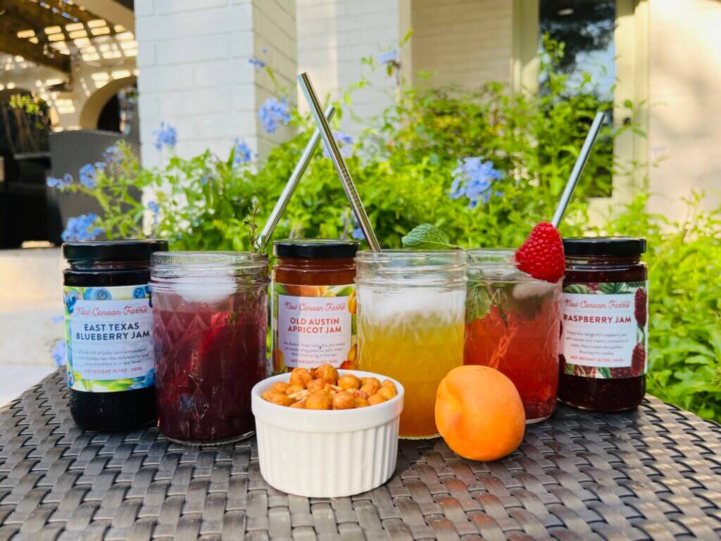 A trio of jam-based cocktails, made with New Canaan Farms jams; Apricot vodka cocktail, blueberry gin and raspberry rum - all served in mason jars