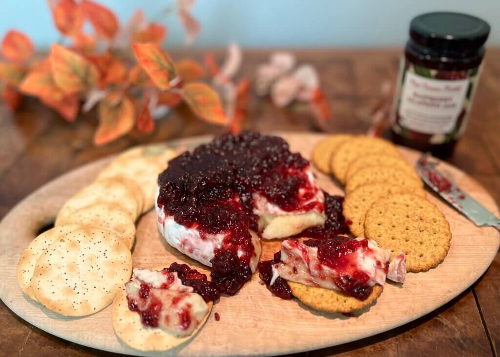 Baked brie and New Canaan Farms Raspberry Jalapeño Jam, surrounded with crackers for a Halloween treat