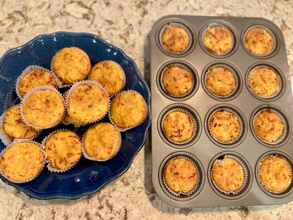 Cranberry Pepper Cornbread muffins, some in a muffin pan and some on a blue plate