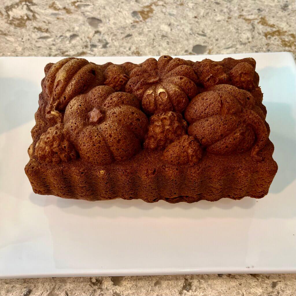 A pumpkin cake, moulded with pumpkin decorations on a white platter