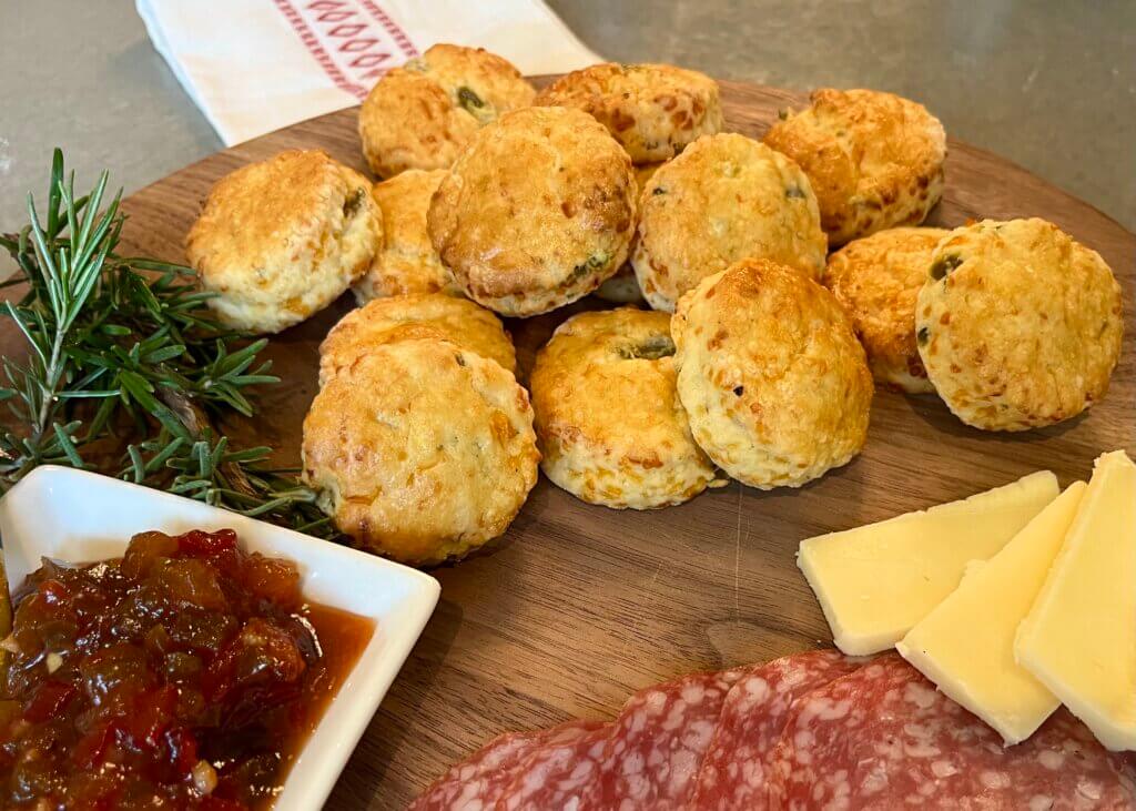 A close-up shot of cheese jalapeño scones on a wooden charcuterie board