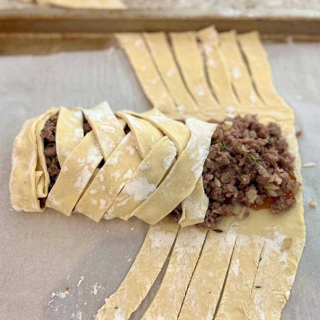 Sausage mixture wrapped into latticed puff pastry