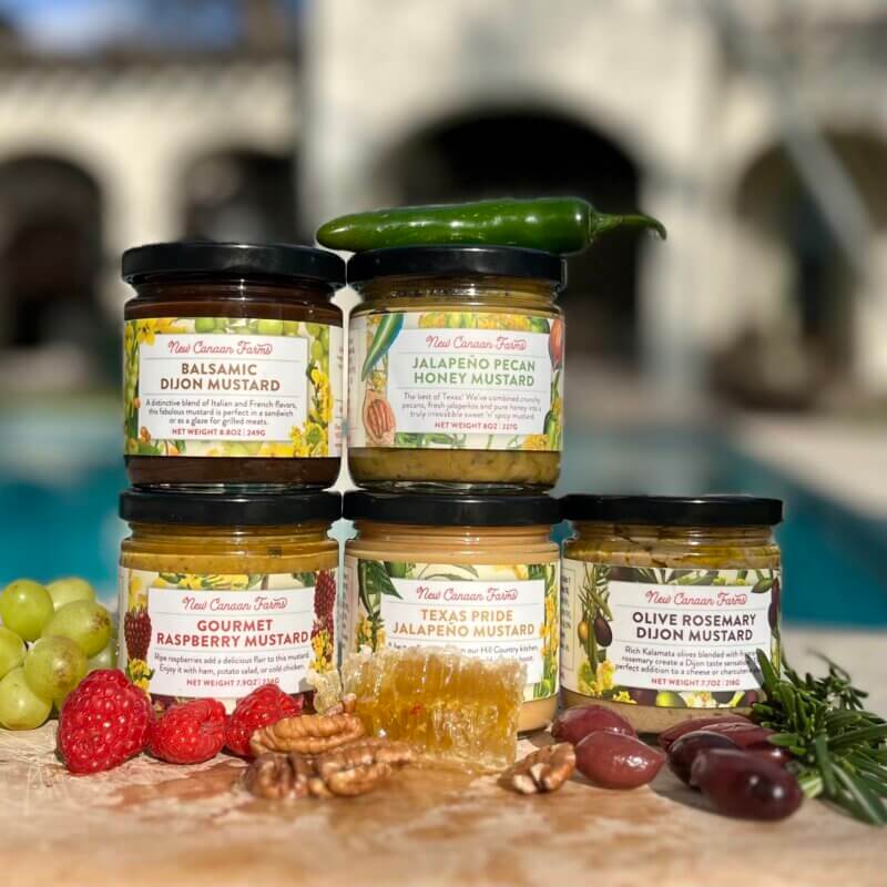 The New Canaan Farms mustard range, on a wooden platter overlooking a swimming pool