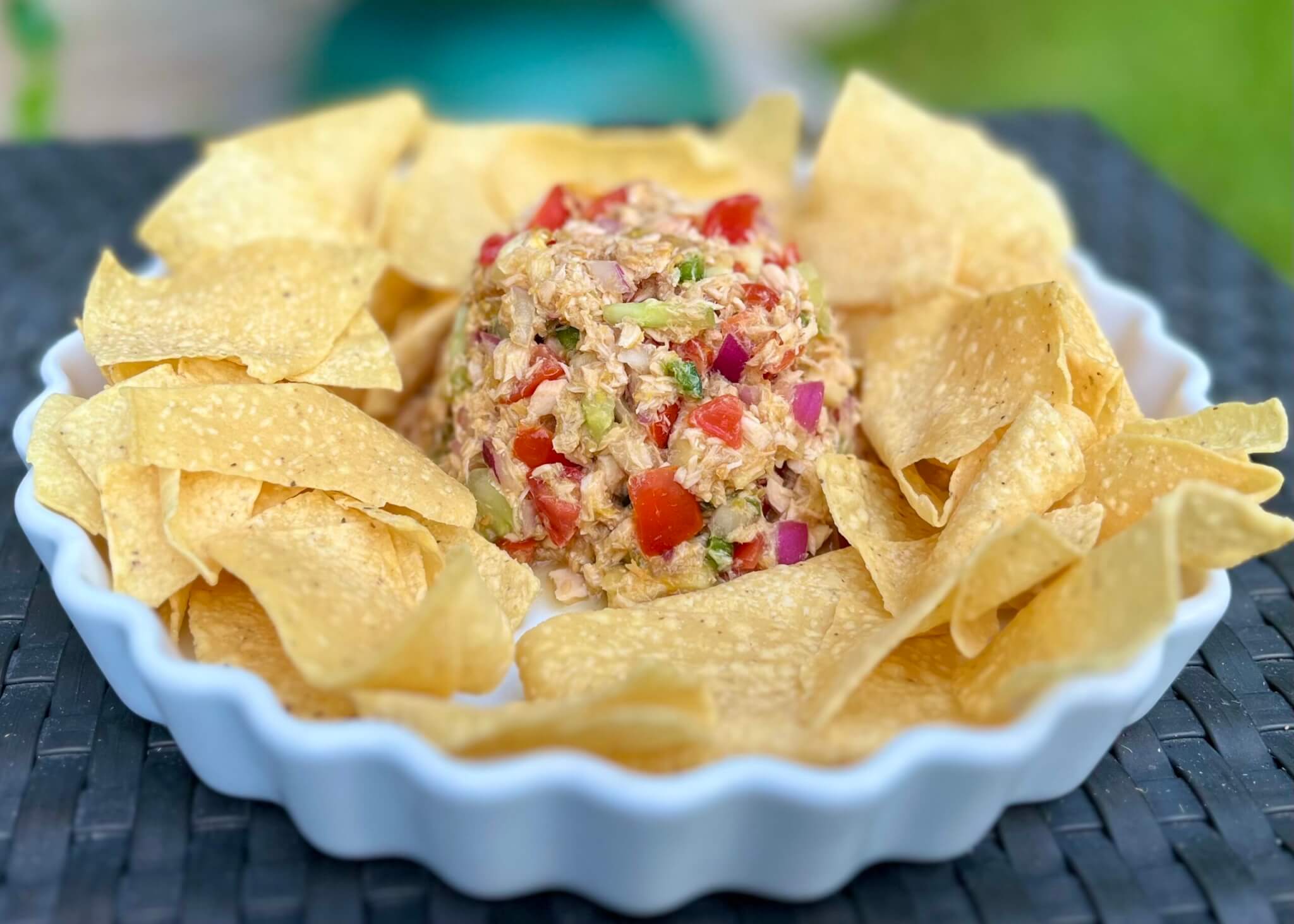 A bowl of salmon ceviche salad, surrounded by tortilla chips