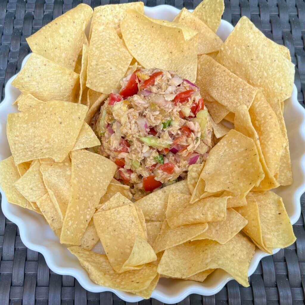 A bowl of salmon ceviche salad, surrounded by tortilla chips