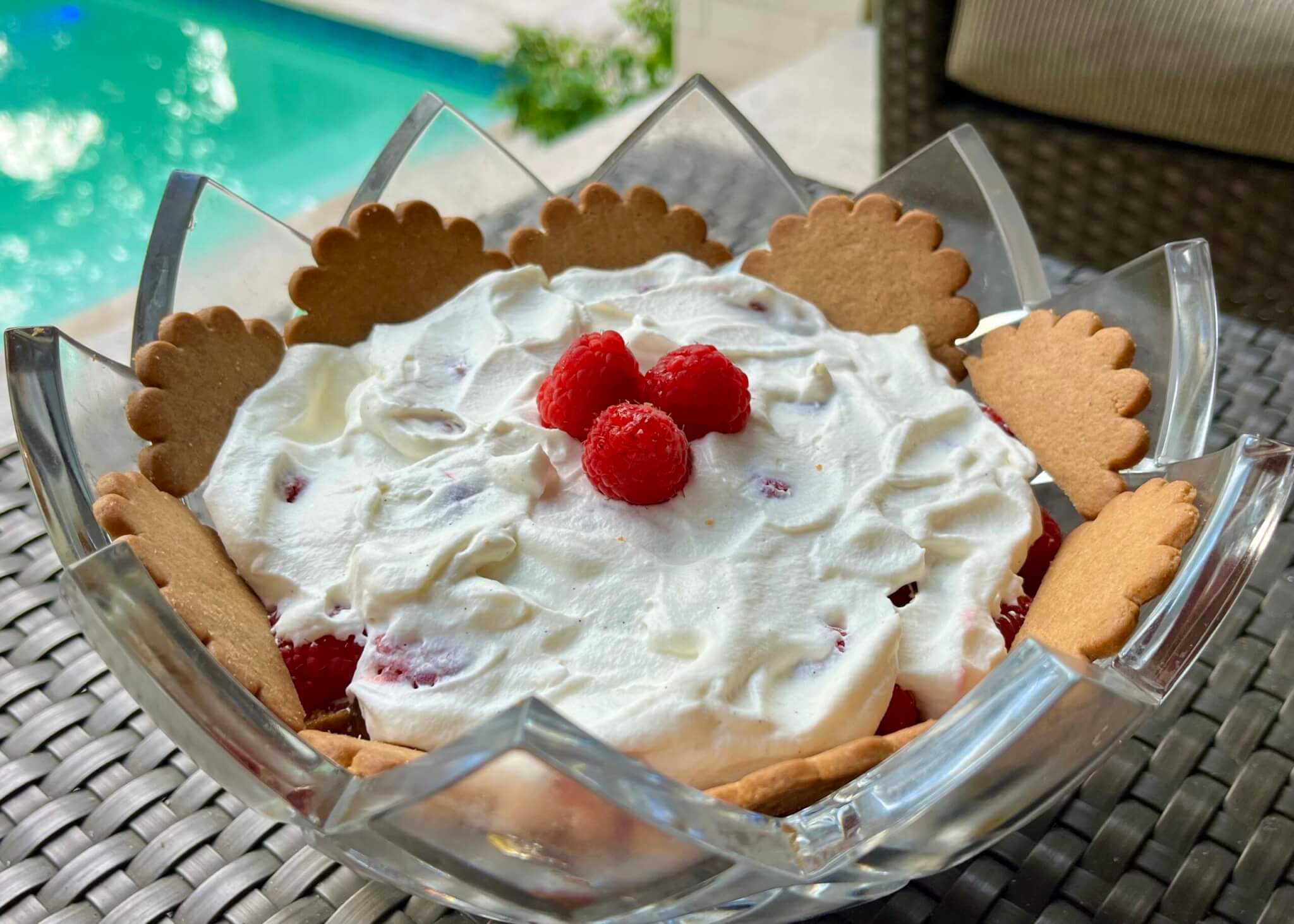 A glass serving bowl containing Peach Raspberry Ginger Trifle, made with New Canaan Farms Fredericksburg Peach Jam