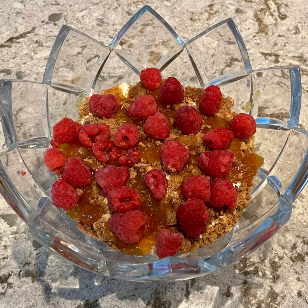 The base of a raspberry ginger trifle - raspberries on top of crumbled ginger cookies