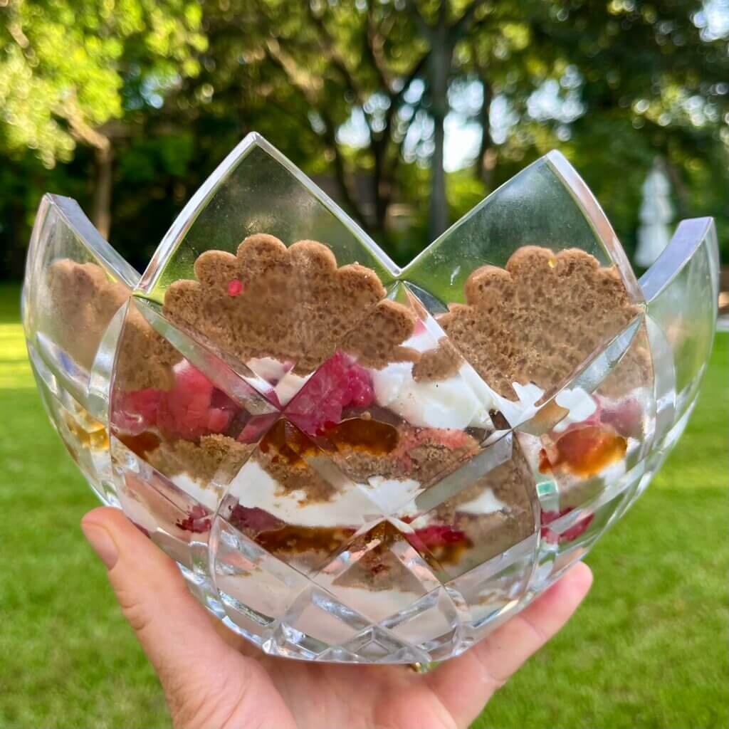 The side view of a Peach Raspberry Ginger Trifle, seen through a glass bowl