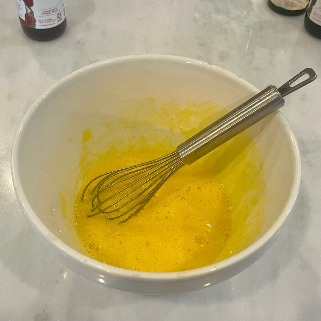 Beaten custard mixture in a white bowl